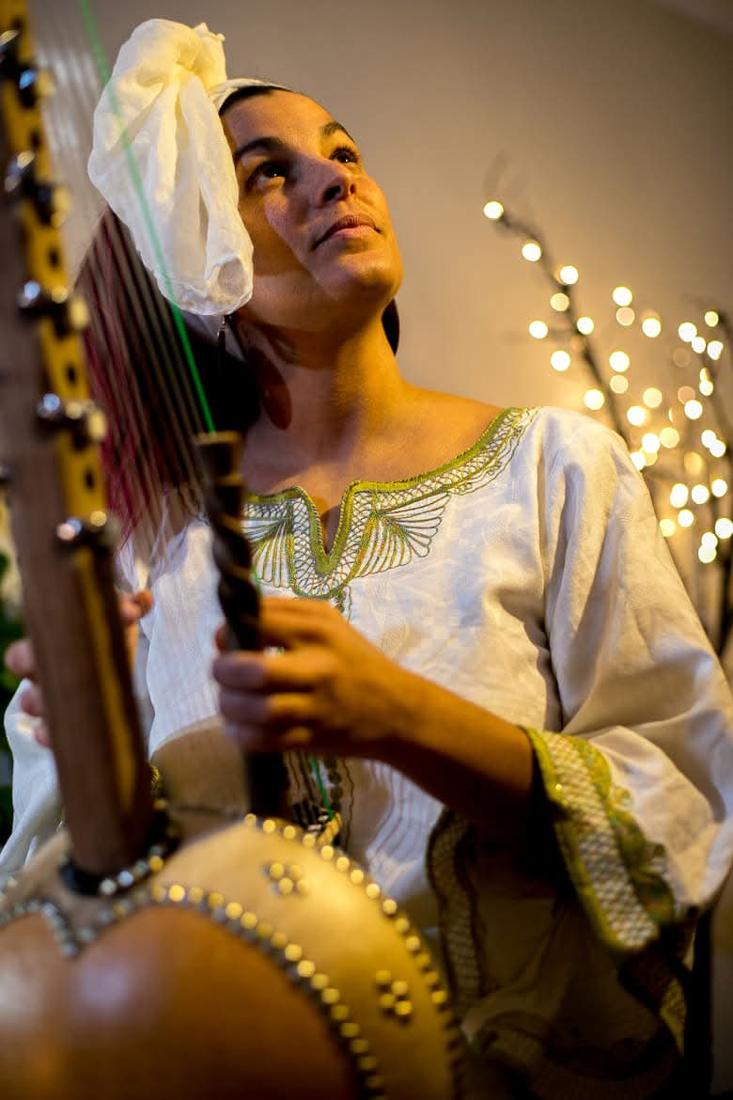 Maïya playing the kora, looking upward